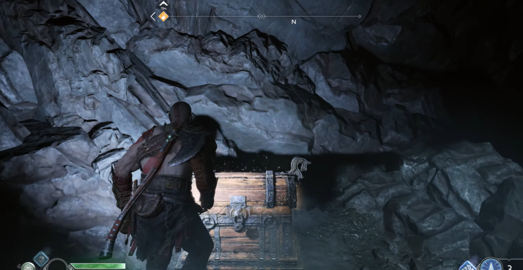 Кратос открывает сундук в каменной пещере God of War