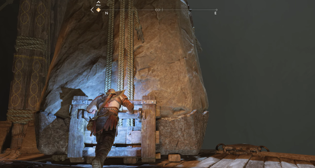 Кратос толкает деревянный механизм у скалы God of War