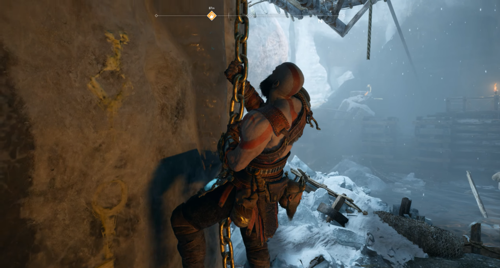 Кратос из God of War карабкается по цепи в снегу