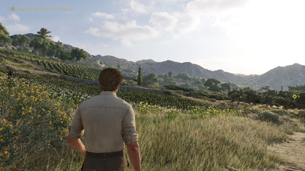 Мужчина стоит на тропе у виноградника в горах